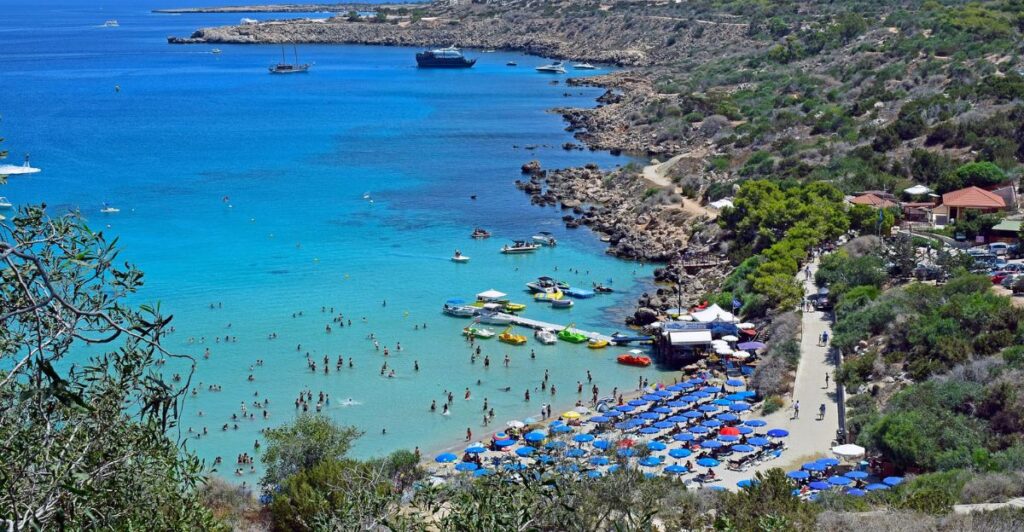 Person planning summer travel destinations on a map with notebook