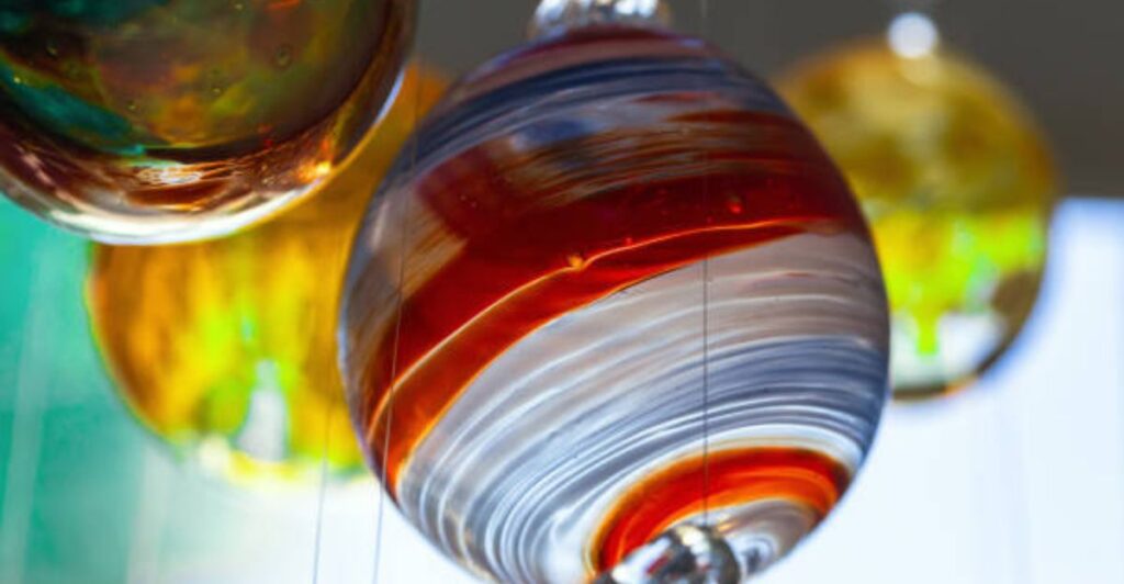 Crystal-clear hanging ball filled with seashells and sand.