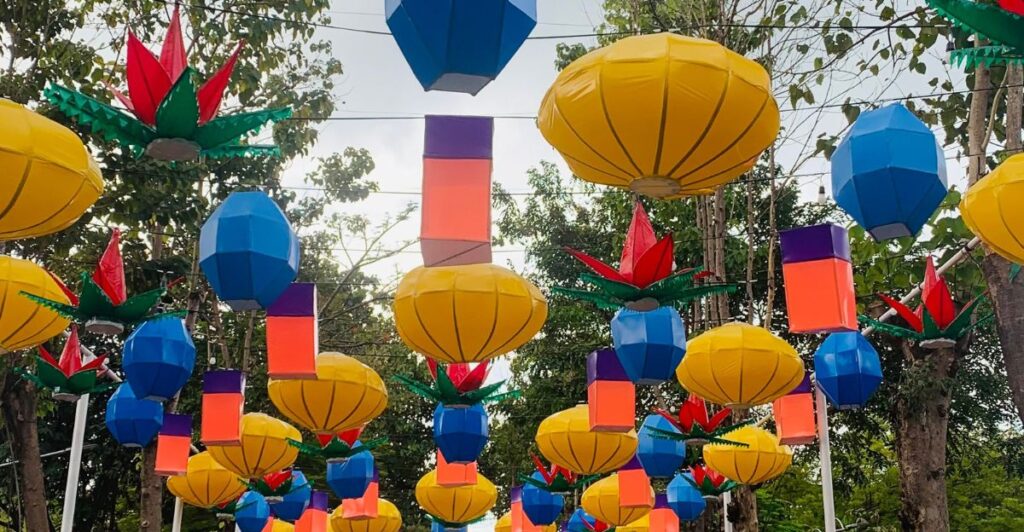 Red, blue, and yellow lanterns lining a backyard path.