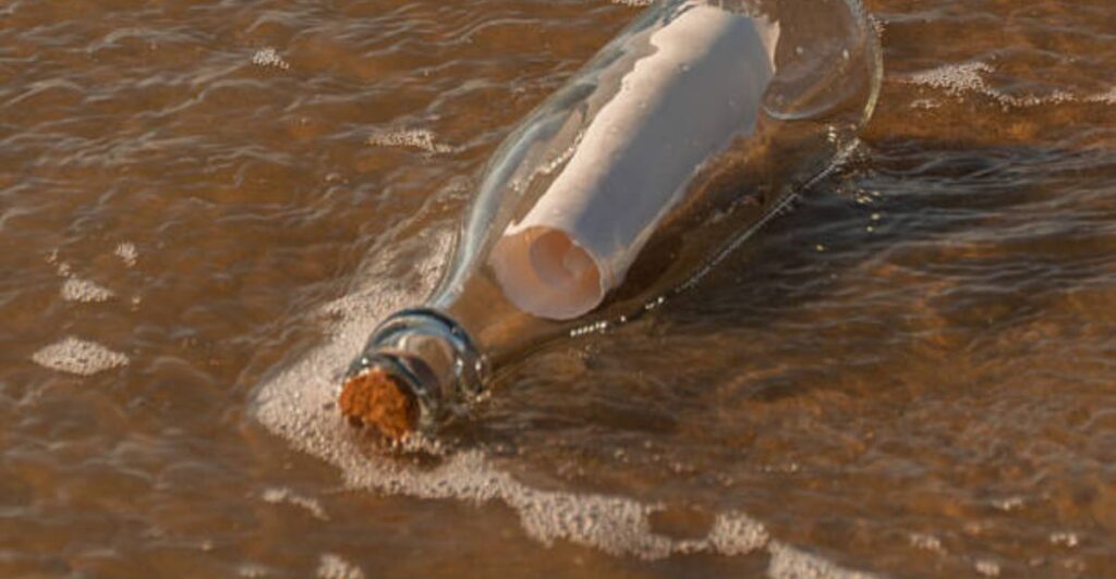 Decorative bottle containing beach sand, shells, and a handwritten family vacation label.