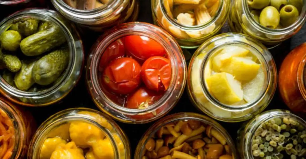 Glass jar storage containers neatly arranged on a modern kitchen countertop with dry pantry staples.