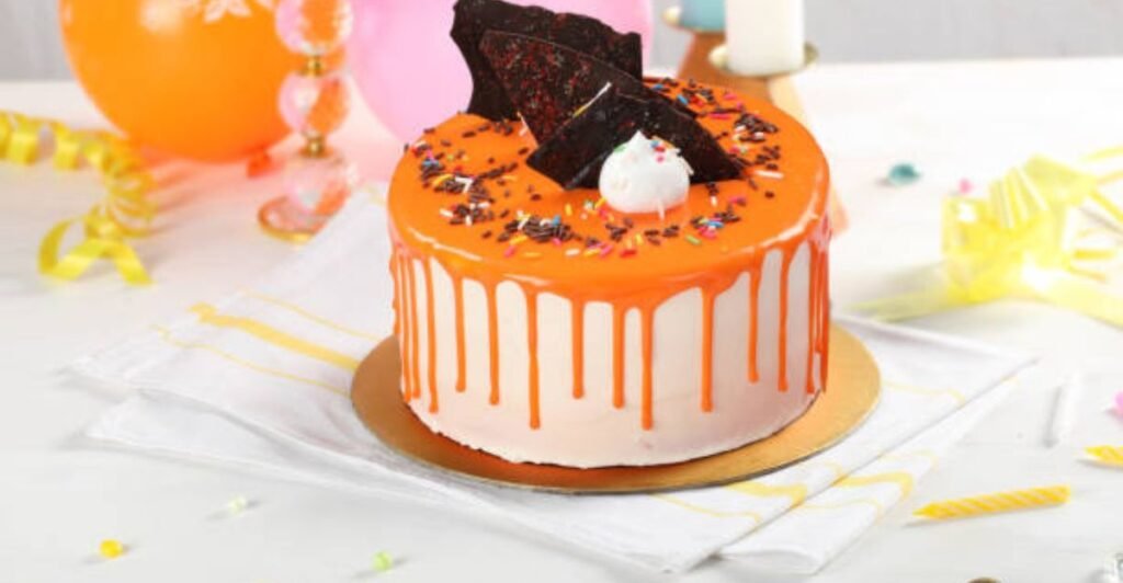 Classic vanilla celebration cake with smooth buttercream frosting and colorful sprinkles on a white cake stand.