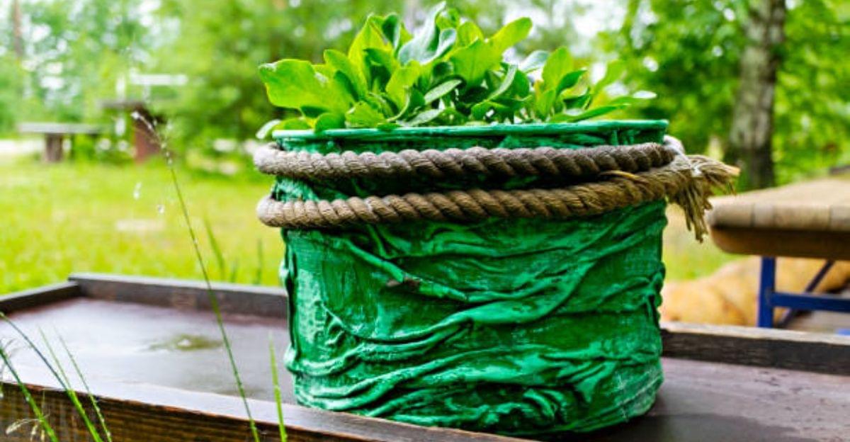 Rustic DIY rope-wrapped flower pot crafted using recycled materials for farmhouse home décor.